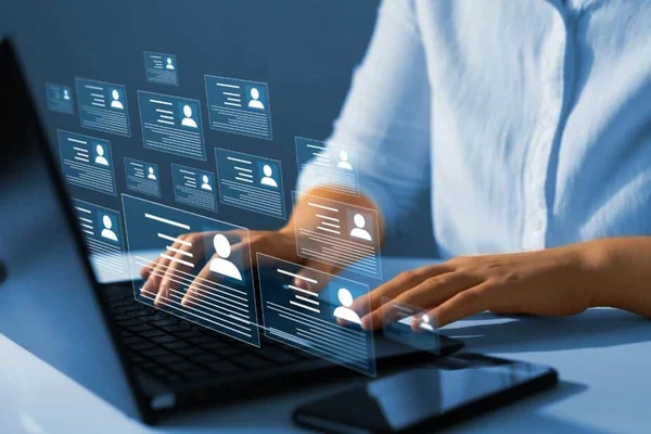 person reviewing many CV's on a laptop