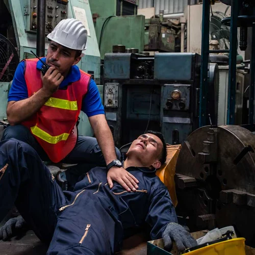 Worker had accident unconscious on the floor at factory. Male engineer supervisor talking on walkie talkie for help. Safety in Factory industrial and drug testing concept.