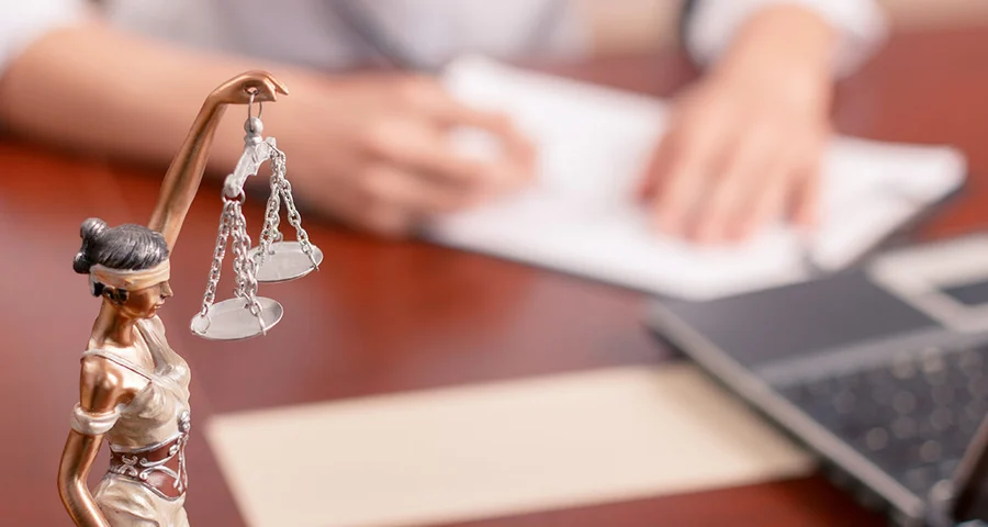 Scales of justice statue on a lawyer's desk