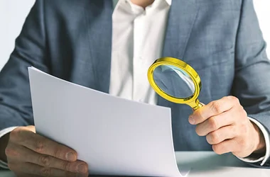 background check businessman reviewing resume with magnifying glass