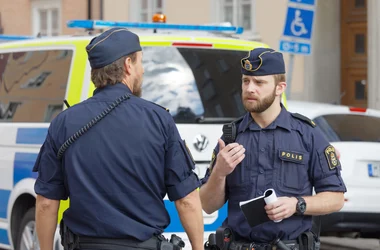 Två poliser som pratar med varandra på gatan