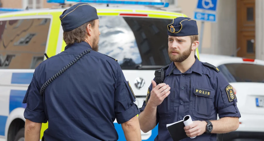 Two police officers talking to each other in the street