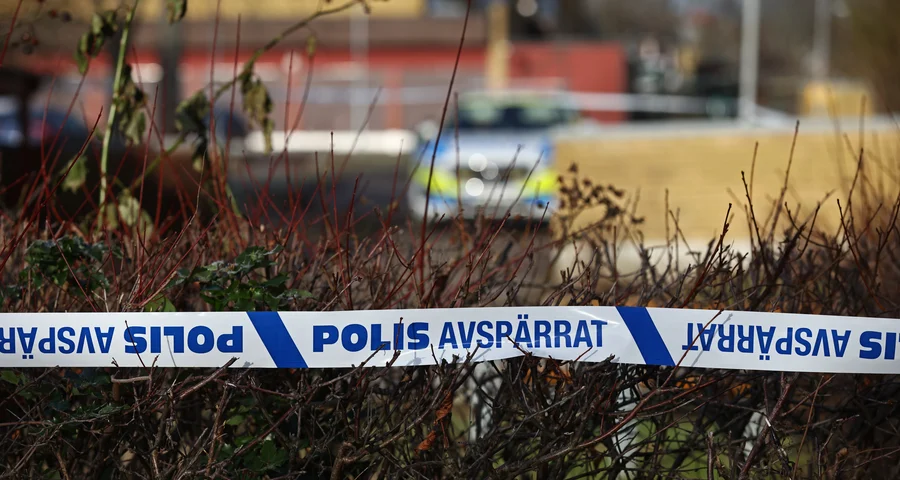 I bakgrunden syns en polisbil och i framkant en polisavspärrning