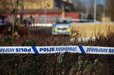 I bakgrunden syns en polisbil och i framkant en polisavspärrning