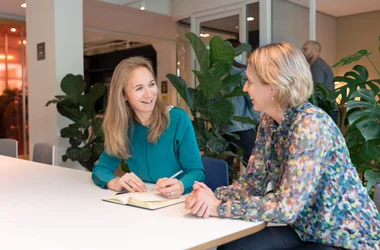 Två kvinnor sitter och diskuterar vad är skillnaden mellan belastningsregistret och bakgrundskontroll