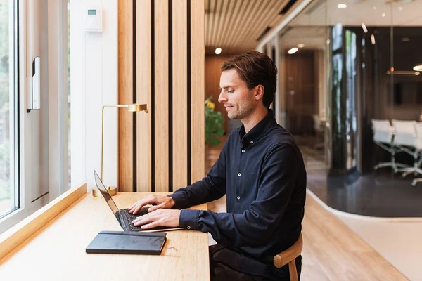 En man sitter vid en dator och läser om bakgrundskontroller
