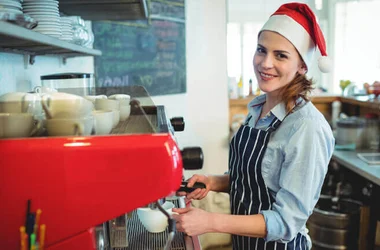 seasonal employee barista wearing santa hat