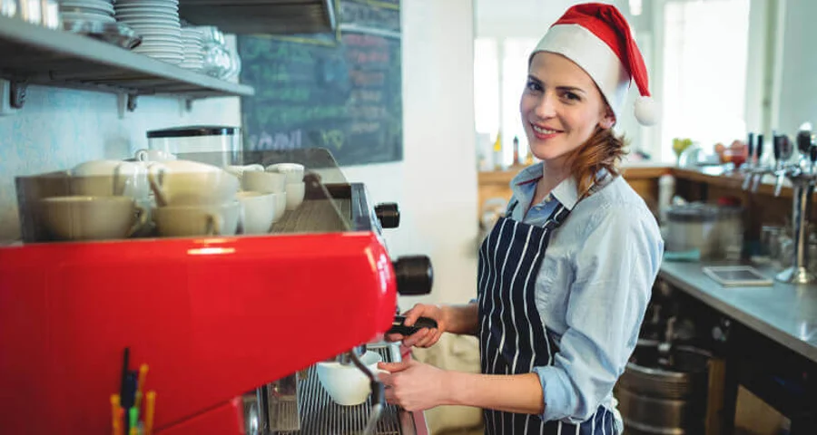 seasonal employee barista wearing santa hat
