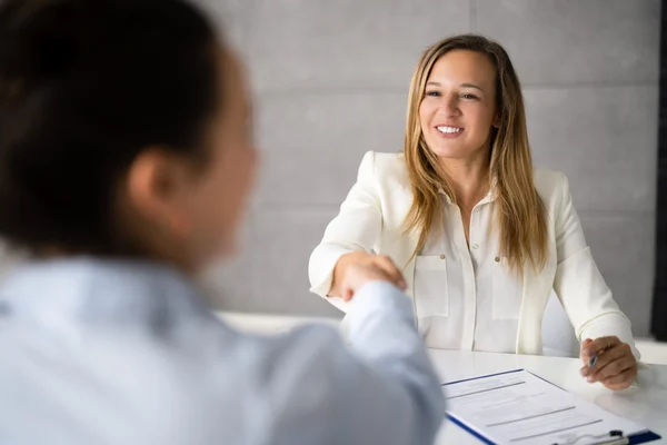 woman shaking the hand of interviewer.