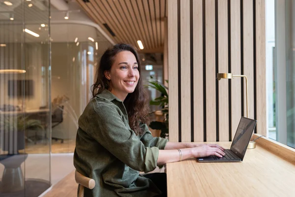 Woman working at laptop olive jumper