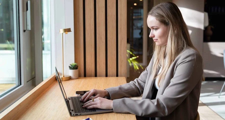 Kvinnlig arbetsgivare sitter vid datorn och kontrollerar anställdas arbetstillstånd dvs rätt att arbeta