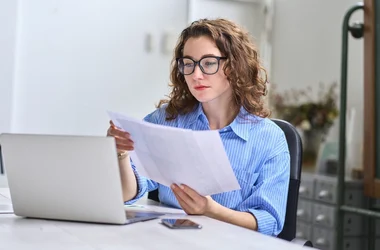 A woman at the workplace is reading about staff vetting regulations