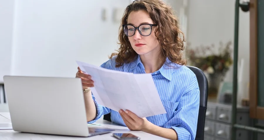 A woman at the workplace is reading about staff vetting regulations