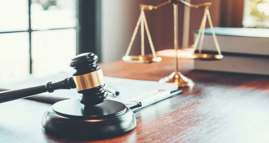 Gavel sitting on a desk with scales of justice
